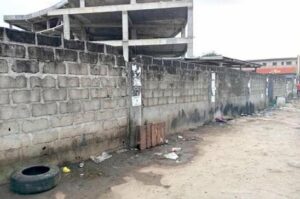 Mur en parpaings et terrain dégradé près de la gare routière de Libreville